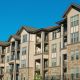 Townhouse Complex with tan colored commercial composite siding blue sky above