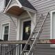 residential grey composite LP siding installation process with ladder